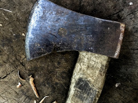 an old axe is laying on a chopping block
