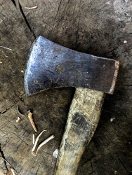 an old axe is laying on a chopping block