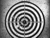 a very perforaded dart board with some darts, black-and-white