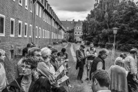 a little group of citizens and politicians is visiting an uninhabited residential area in unterlüß, black-and-white