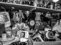 visitors rummage in many stuff on a flea market at the evangelical mission in hermannsburg, black-and-white