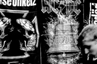 a young man is passing a stand with heavy metal stuff on a market in müden örtze, black-and-white