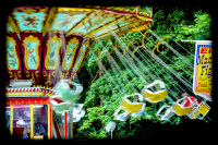 a chain carousel at a funfair in faßberg is turning around in front of green trees