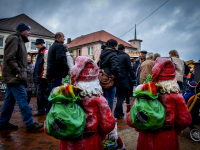 visitors of a christmas market in bergen in lower saxony are passing two little santafigures