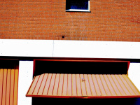 in bergen in lower saxony is standing an orange house with two windows and in front of it an open orange garage