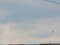 at a military day in faßberg a transport helicopter and a little dragon fly are flying over an old military aircraft