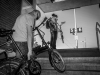 two trainpassengers at the train station in unterlüß  are carry up her bikes to the platform, black-and-white