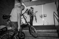 two trainpassengers at the train station in unterlüß  are carry up her bikes to the platform, black-and-white