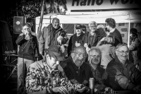 at a hunter meeting in müden örtze some hunters are laughing about the imitated sound of a deer wild call, black-and-white