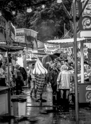 visitors of the laurentius market in müden are seeking protection at the stands for a downpour, black-and-white