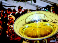 in front of celebrating guests of the rifle club festival in bergen the music band is playing, inter alia a yellow shiny tuba
