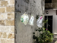 in a court in the old town of rhodes are hanging three plastic bags on a clothes line for drying