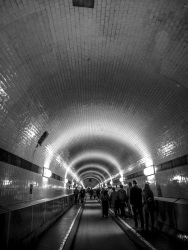 view in the old tunnel under the elbe in hamburg where people are going for a walk, black-and-white