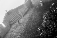 a little boy is running over a plattform of the castello della guaita in san marino, black-and-white