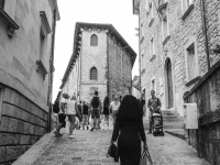 an elegant italian woman is walking up a street in san marino, black-and-white