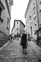 an elegant italian woman is walking up a street in san marino, black-and-white