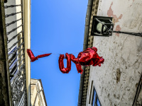 red shiny ballons with lettering love are hanging between houses in front of the blue sky in bovino in puglia
