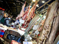 a lot of raw meat and offals is hanging in the halls of the central market in athens
