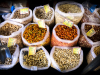 a dozen bags full of various nuts are for sale on the market in aegio