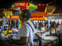 a man with headphones is standing on a colorful funfair in kremasti on rhodes
