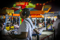 a man with headphones is standing on a colorful funfair in kremasti on rhodes