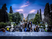in a blue evening light people are coming the steps up on the syntagma place in athens