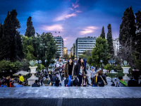 in a blue evening light people are coming the steps up on the syntagma place in athens
