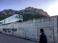 a young man is looking to a train that just is coming to the village diakopto