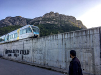 a young man is looking to a train that just is coming to the village diakopto