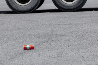 in front of two big truck wheels rolls an orange can of vap lemonade near gennadi on rhodes