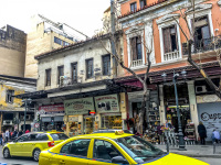 two yellow taxis are driving on the street athinas in the centre of athens