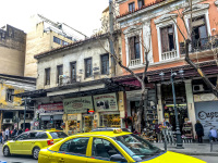 two yellow taxis are driving on the street athinas in the centre of athens