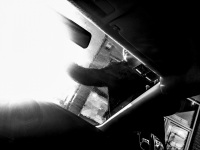 view out of the car there is a young man who cleans the windshield near ioannina, black-and-white