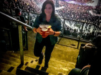 a woman on the steps in the volksparkstadion in hamburg at the metallica concert brings three beers for thursty friends