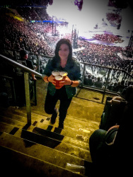 a woman on the steps in the volksparkstadion in hamburg at the metallica concert brings three beers for thursty friends