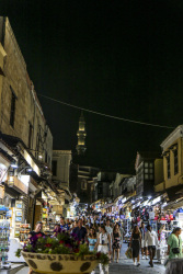 illuminated shops and many tourists by night in the socrates street in rhodes city