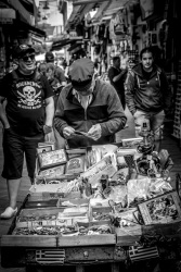 an old street vendor with his sales cart in a street in monastiraki in athens, black-and-white