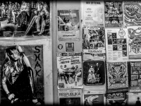 a wall with posters of musicians in a passage in monastiraki in athens, black-and-white