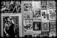 a wall with posters of musicians in a passage in monastiraki in athens, black-and-white
