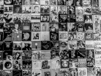 in a passage in monastiraki in athens is a wall full of lp covers of international musicians, black-and-white