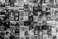 in a passage in monastiraki in athens is a wall full of lp covers of international musicians, black-and-white