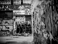 an empty street in monastiraki in athens with walls full of graffiti, black-and-white