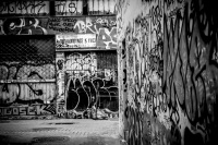 an empty street in monastiraki in athens with walls full of graffiti, black-and-white