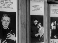 three big placards with greek musicians are hanging in front of the herodes atticus theatre near the acropolis in athens, black-and-white