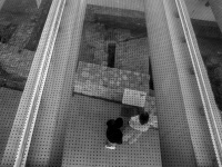 view in the lower area of the acropolis museum in athens where two people watching old stonewalls, black-and-white