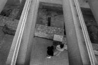 view in the lower area of the acropolis museum in athens where two people watching old stonewalls, black-and-white
