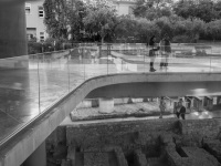 the entrance of the acropolis museum in athens with the lower and the upper area and with some tourists, black-and-white