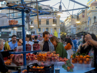 customers at a fruit stand at the monastiraki square in athenswith fresh peaches, aprictos, oranges and cherries