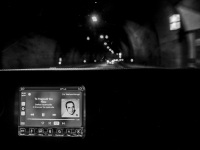 view out of a car in tunnel near gavrolimni, in front the navi shows that the tape is playing music of stelios kazantzidis, black-and-white