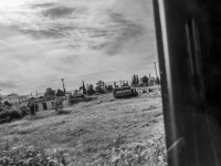 view out of a jeep wranlger in a landscape near euboea with old houses and worker, black-and-white